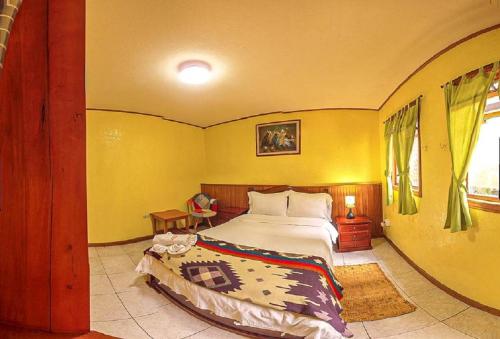 a bedroom with a bed and a yellow wall at La Casa del Molino Blanco B&B in Baños