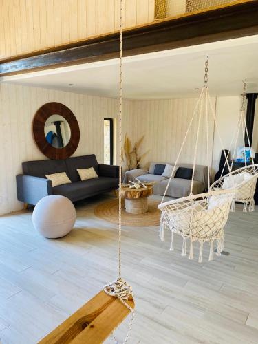 - un salon avec une balançoire et un canapé dans l'établissement la P’tite Grange, à La Cotinière