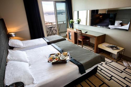 a hotel room with a large bed with a tray of food on it at Cihangir Hotel Bosphorus in Istanbul