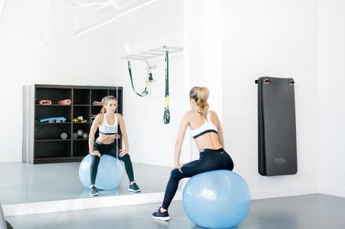 two girls are sitting on balls in a gym at Level Los Angeles - Downtown South Olive in Los Angeles