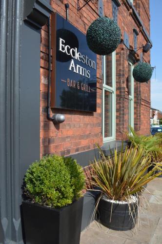 a sign on the side of a brick building with plants at The Eccleston Hotel; BW Signature Collection in Saint Helens