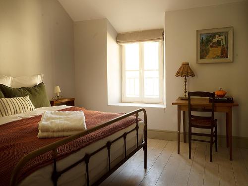 1 dormitorio con cama, escritorio y ventana en The Riverhouse, magical house with garden by the river Seine, en Gyé-sur-Seine