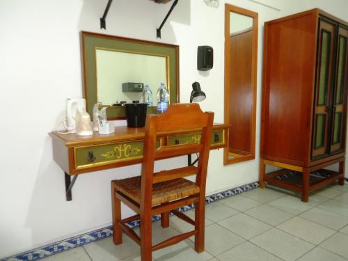 a dressing table with a chair and a mirror at Hotel Concierge Plaza Colima in Colima