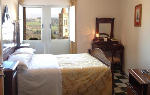 a bedroom with a bed and a window with a tower at Albergo Hotel Raffaello in Urbino