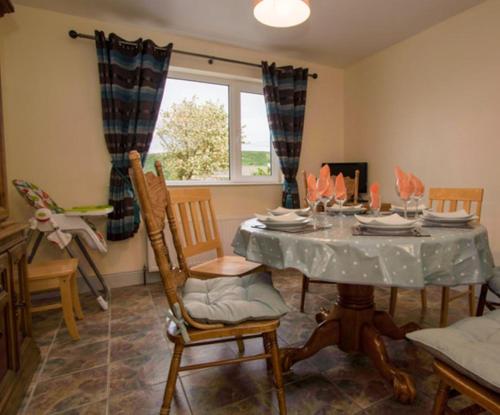 a dining room with a table with chairs and a window at Hillview Holiday Home in Clonmany