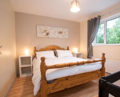 1 dormitorio con cama de madera y ventana en Hillview Holiday Home, en Clonmany