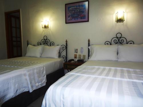 two beds sitting next to each other in a bedroom at Hotel Concierge Plaza Colima in Colima