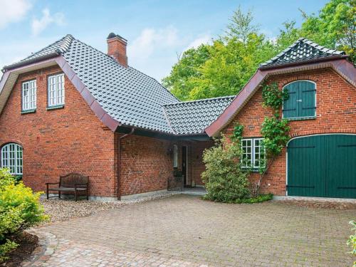 una casa de ladrillo rojo con un garaje verde en 7 person holiday home in Krus, en Kruså