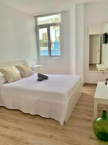 a bedroom with a large white bed with a window at Apartamento El Malecón in Santa Cruz de la Palma