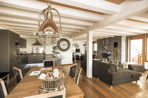 a dining room and living room with a table at Crans Luxury Lodges in Crans-Montana