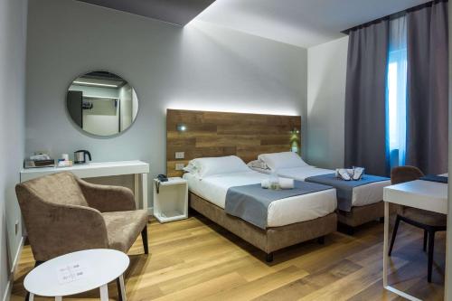 a hotel room with two beds and a chair at Best Western Hotel Turismo in San Martino Buon Albergo