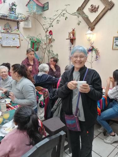 a woman holding a cup in a room full of people at Hotel Chalet in Chichicastenango