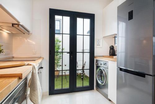a kitchen with a door leading to a washer and dryer at Villa palmera jacuzzi in Yaiza