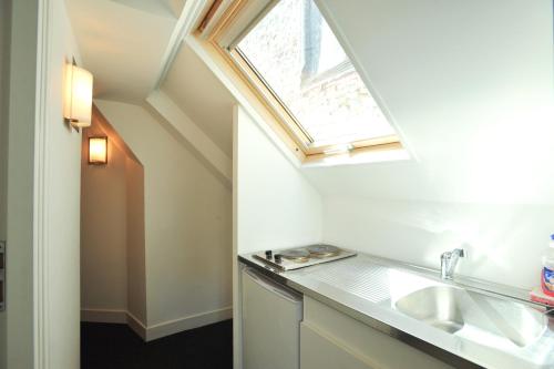 ein Badezimmer mit einem Waschbecken und einem Dachfenster in der Unterkunft Chambres d'Hôtes La petite Salamandre in Étretat