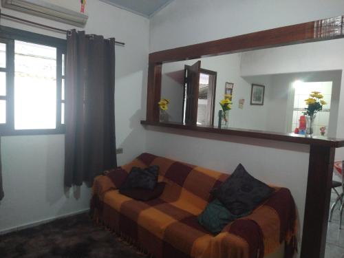 a living room with a couch and a mirror at Casa para fins de semana/feriado in São Sebastião