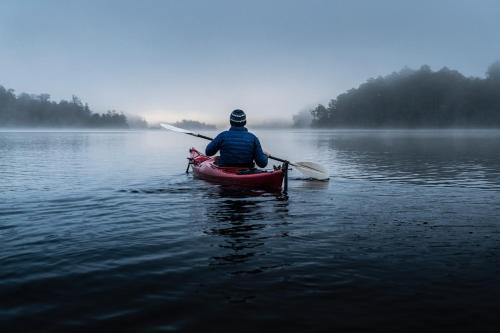 a man in a red kayak on a lake at Tullah Lakeside Lodge in Tullah