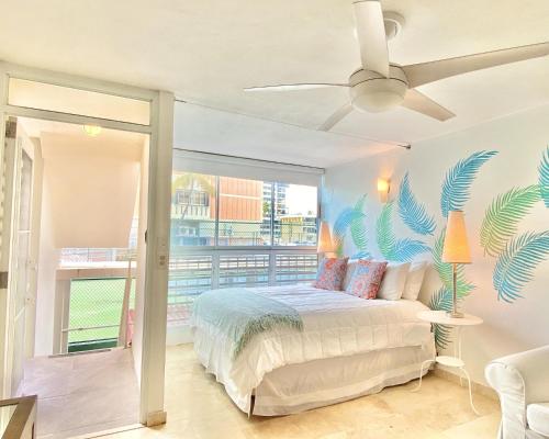 una camera da letto con un letto e un murale tropicale sul muro di KASA El Sol by the Sea with Pool and Parking a San Juan