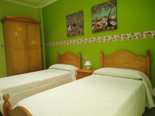 2 camas en una habitación verde con paredes verdes en Casa de Xerta en Xerta