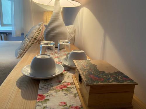 una mesa de madera con dos tazas y platos. en Boutique Aparthotel, en Cracovia