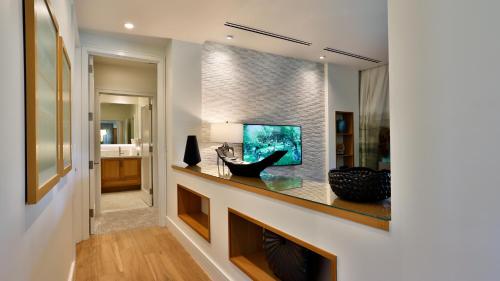a living room with a fish tank on a wall at Maui Westside Presents: Luana Garden Villas 14D in Kaanapali