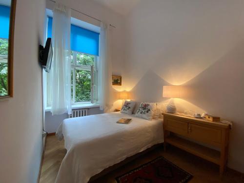1 dormitorio con cama blanca y ventana en Boutique Aparthotel, en Cracovia