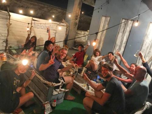 a group of people sitting in crates with their hands in the air at guest house Holoholo Ishigakijima in Ishigaki Island