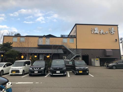 a parking lot with cars parked in front of a building at Kanazawa-Hachitabi Sennichi in Kanazawa