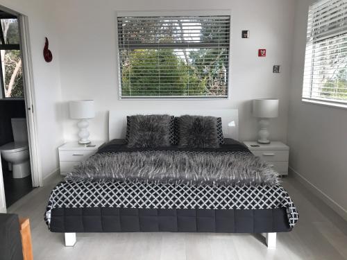 a bedroom with a black and white bed and a window at Sea La Vie - Waiheke Island Luxury Accommodation in Onetangi