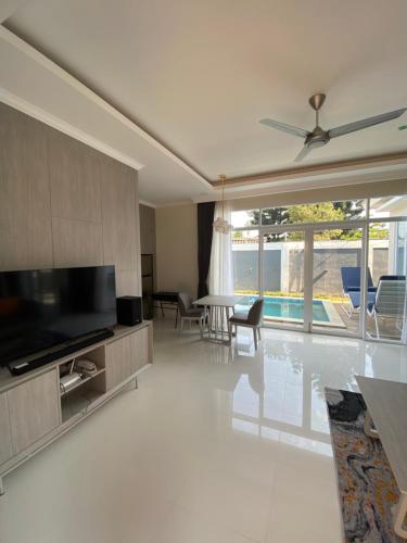 a living room with a large television and a living room with a pool at Marseillia Hills in Puncak