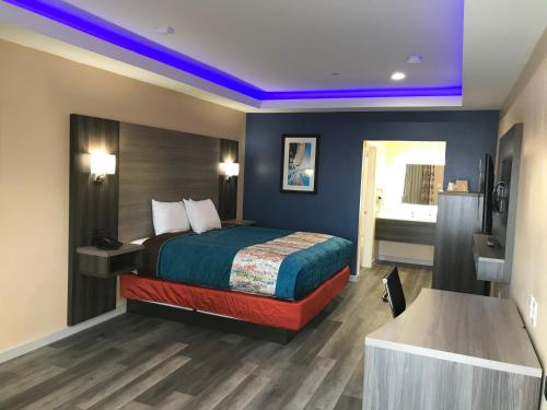 a hotel room with a bed and a bathroom at Scottish Inn & Suites Houston Willowbrook in Houston