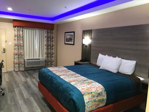 a hotel room with a large bed in a room at Scottish Inn & Suites Houston Willowbrook in Houston