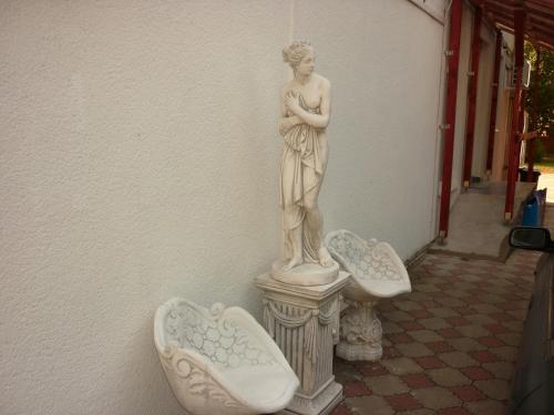 a statue of a woman standing on a pedestal at R1 Rolléder Apartman-ház in Siklós