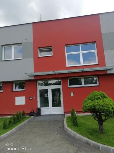 a red and white building with a driveway at Penzion ValMez in Valašské Meziříčí