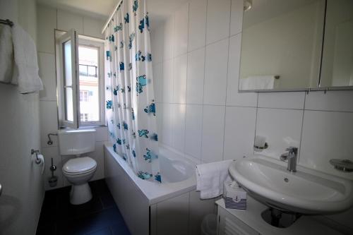 ein weißes Bad mit einem WC und einem Waschbecken in der Unterkunft Ferien in Glarus in Glarus