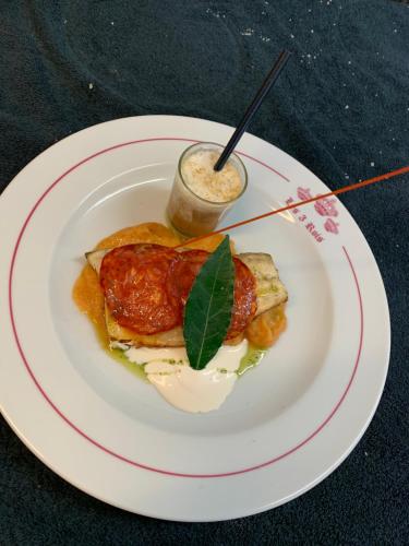 a white plate with food on a table at Les 3 rois by YY in Villers-Bocage