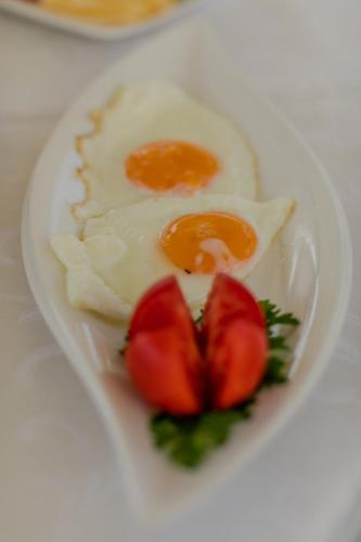 a plate of food with eggs and strawberries on a table at Hotel Concordia in Trogir