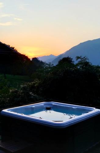a hot tub with the sunset in the background at il Battito in Saint Vincent