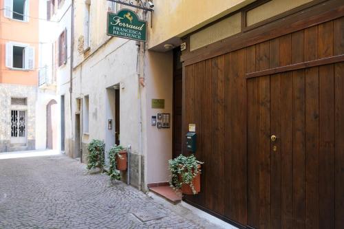 a building with a wooden door on the side of a street at Residence Ferraud in Pinerolo