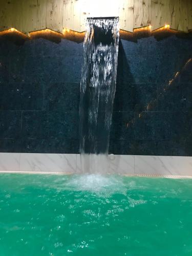 a water fountain in a swimming pool at Park Hotel Avisio in Soraga