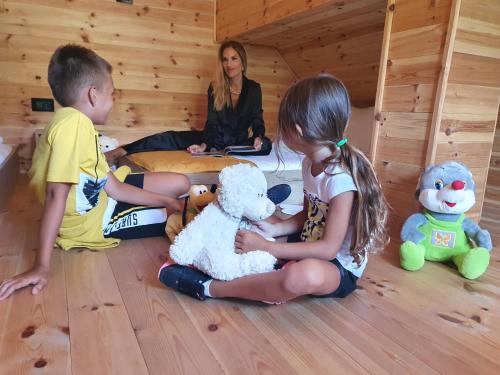a little girl and boy playing with stuffed animals in a room at Dream House Hotel & Spa in Kolašin