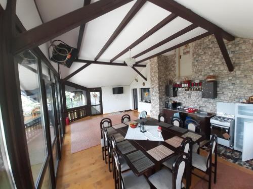 an open kitchen and dining room with a table and chairs at CASA DINTRE PINI in Păltinoasa