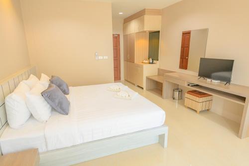 a bedroom with a white bed and a television at Avarin Resort in Pak Chong
