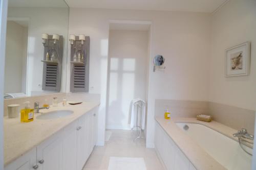 une salle de bain blanche avec une baignoire et un lavabo dans l'établissement Champs Elysees, à Paris