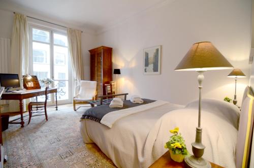 um quarto com uma cama, uma secretária e uma mesa em Champs Elysees em Paris