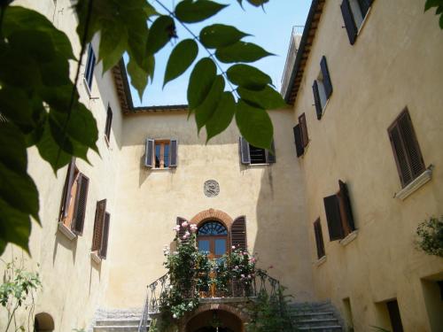 a building with a balcony with flowers on it at B&B Il Glicine in Montefollonico