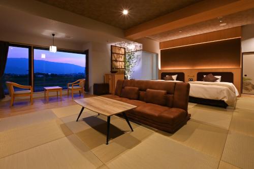a bedroom with a couch and a bed and a table at 原鶴の舞 in Asakura