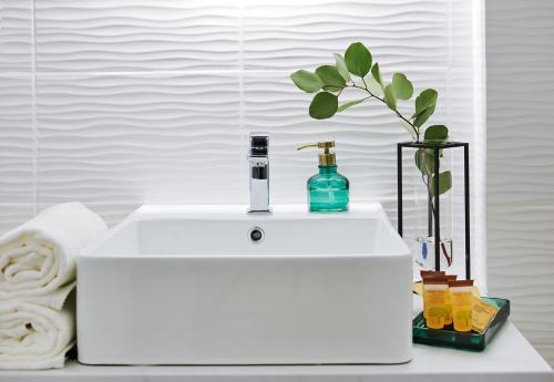 a white sink with a bottle and a plant on it at Noclegi Pod Sokołem in Sokółka