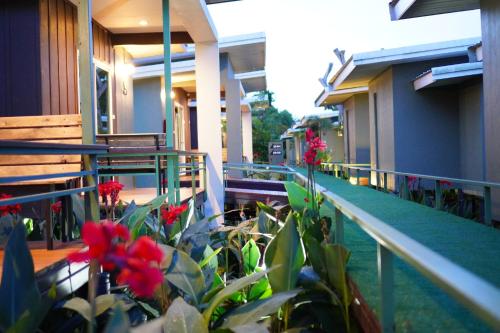a balcony of a building with red flowers on it at Green Two Resort in Chanthaburi