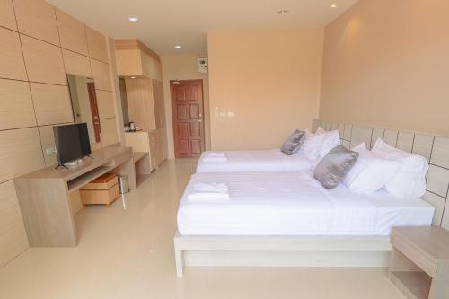 a hotel room with two beds and a television at Avarin Resort in Pak Chong