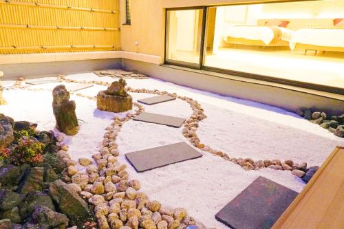 a room with a bed and a room with a rock floor at 原鶴の舞 in Asakura